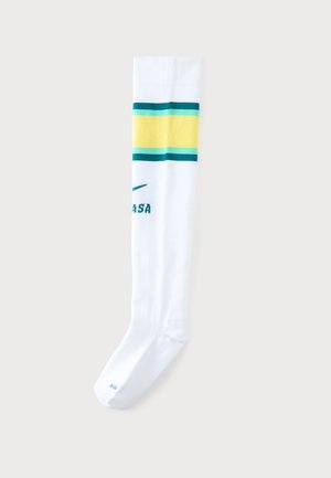 Chaussette blanche montante unique avec des rayures jaunes et vertes près du haut et un texte vert partiel sur le côté.