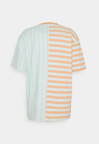 Camiseta de manga corta con rayas verticales y horizontales alternas; colores azul claro y durazno; material de algodón; diseño de cuello redondo.