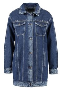 Džínová bunda v tmavě modré barvě se stříbrnými hroty, dvěma předními kapsami, zapínáním na knoflík a kontrastním světle modrým prošíváním podél švů.