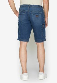 Pantaloni shorts in denim, blu scuro, con doppie tasche posteriori e una tasca laterale cargo. Rifiniti con cuciture a contrasto e una vestibilità rilassata.