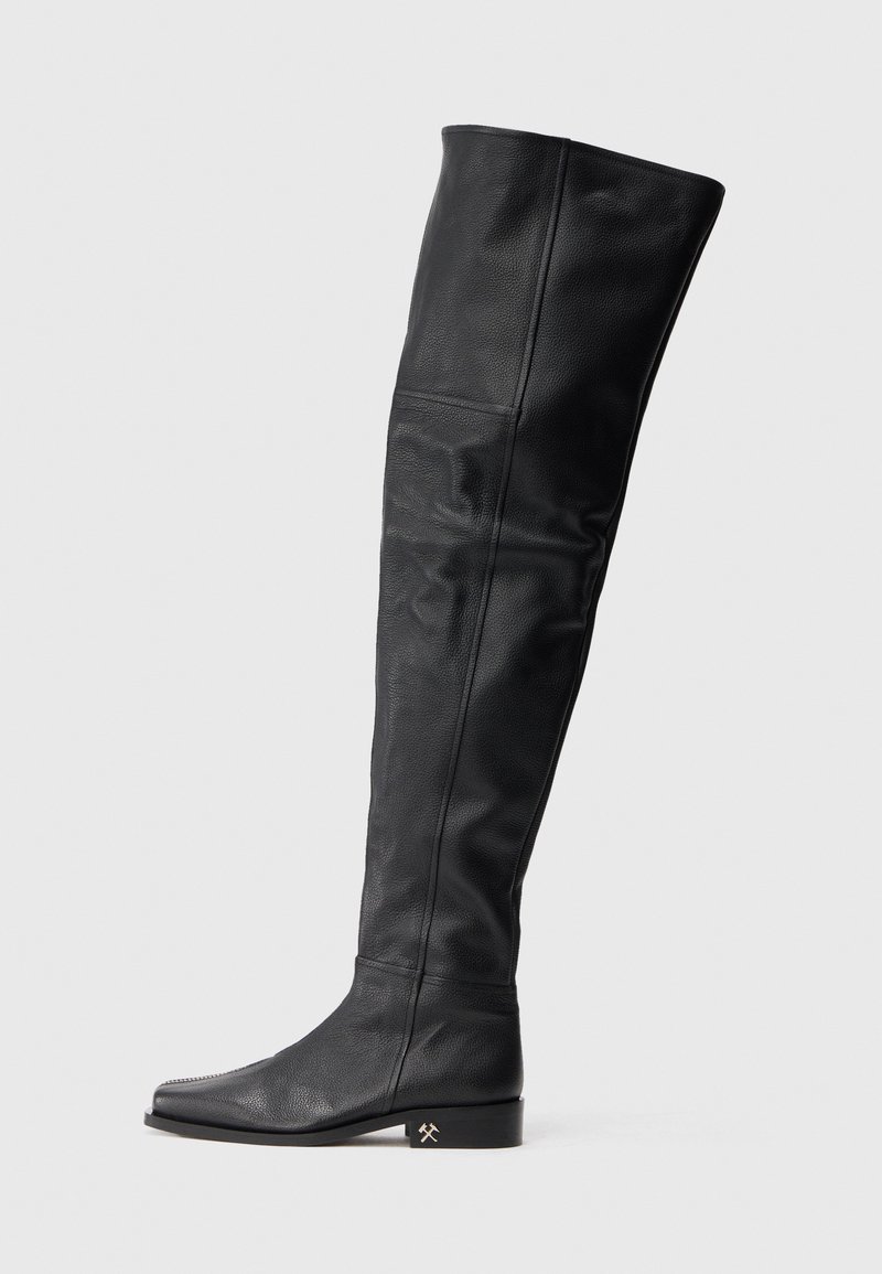 Botas de cuero negras altas hasta la rodilla con un diseño ajustado, puntera puntiaguda y un tacón bajo tipo bloque con un acento metálico. Textura suave en toda su superficie.