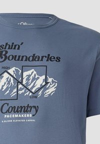 Blauses Baumwoll-T-Shirt mit Rundhalsausschnitt. Es zeigt eine Grafik von Bergen und schwarzen Text, darunter "Shin' Boundaries" und "Country Pacemakers."