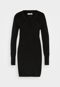 Abito maglione nero a maglia con maniche lunghe, scollatura a V e vestibilità ampia. Con una texture liscia e lunghezza a metà coscia. Etichetta visibile all'interno del colletto.