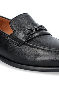 Czarne skórzane mokasyny z teksturowaną powierzchnią, płaską podeszwą i dekoracyjnym łańcuszkiem na pasku. Klasyczny, okrągły kształt noska.