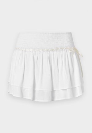 Valge kihiline seelik elastse vöökoht, millel on tekstureeritud smocking detail ja dekoratiivne paela aktsent. Puuvillane kangas.