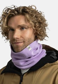 Purple knitted neck warmer with a soft texture, featuring a small logo tag. Worn over a black jacket, with a relaxed, cylindrical design.