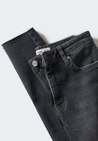 Jean skinny en denim noir plié, avec fermeture par bouton, fermeture éclair, poche avant, passants de ceinture et une étiquette de taille visible à l'intérieur de la ceinture.