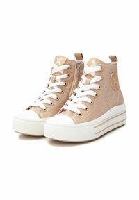 Zapatillas altas beige de lona con puntera y suela de goma blanca, que presentan cordones blancos, cremallera lateral y parche con logo.