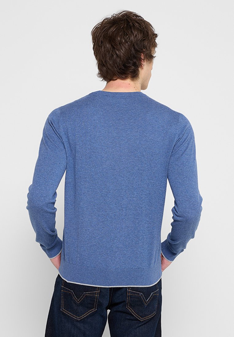 Blauer Pullover aus weichem Strickmaterial. Mit langen Ärmeln, einem runden Ausschnitt und gerippten Bündchen sowie Saum mit glatter Textur.