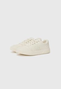 Sneakers blancs avec des panneaux latéraux texturés, bout rond et fermeture à lacets. Fabriqués en matériau lisse avec une semelle en caoutchouc.