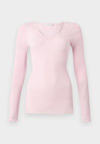 Rosa ribbad långärmad topp med V-ringning och vågig spetskant. Mjuk textur, figurnära passform och rak nederkant.