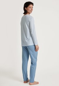 Langärmliges oberteil in blau-weiß gestreift, kombiniert mit einfarbigen hellblauen Hosen, beide aus weichem Baumwollstoff mit lockerer Passform.