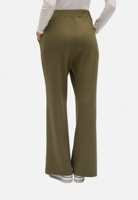 Pantalones de color verde oliva hechos de una tela suave, con una cinturilla alta y piernas anchas, con bolsillos laterales y una textura lisa.