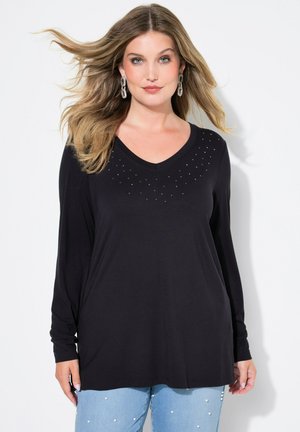 Haut noir à manches longues avec décolleté en V, orné d'une rangée de petits clous métalliques le long de l'encolure. Tissu doux, coupe décontractée.