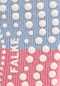 Chaussettes en tricot avec une partie supérieure bleu clair et une partie inférieure rose ornée de points blancs en relief, tricot texturé, et logo "FALKE" en blanc.