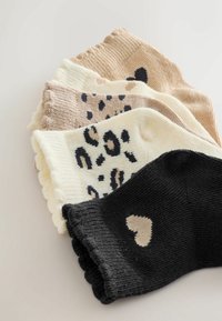 Five pairs of socks: two in beige, one cream with black spots, one black with a heart, plus textured ribbed fabric. Scalloped edges.