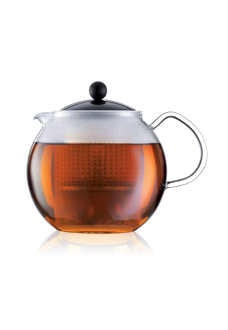 Tetera de vidrio con tapa negra llena de té ámbar infusionado, mostrando el infusor incorporado en el interior y un mango transparente en el lado derecho.