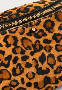 Leopard print handbag featuring a soft, textured surface with warm orange and black patterns; includes a gold zipper and stud detail.