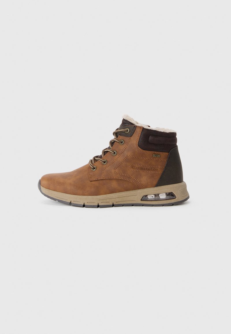 Brown leather ankle boot with a padded collar, metal eyelets, and a brown rubber sole featuring a visible air cushioning unit.