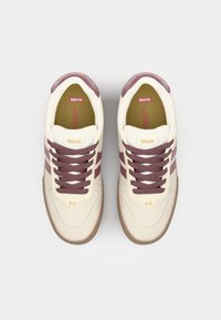 Cream and burgundy sneakers with brown soles. Features include laces and a "Globe" logo on the tongue and side. Positioned on a white background.