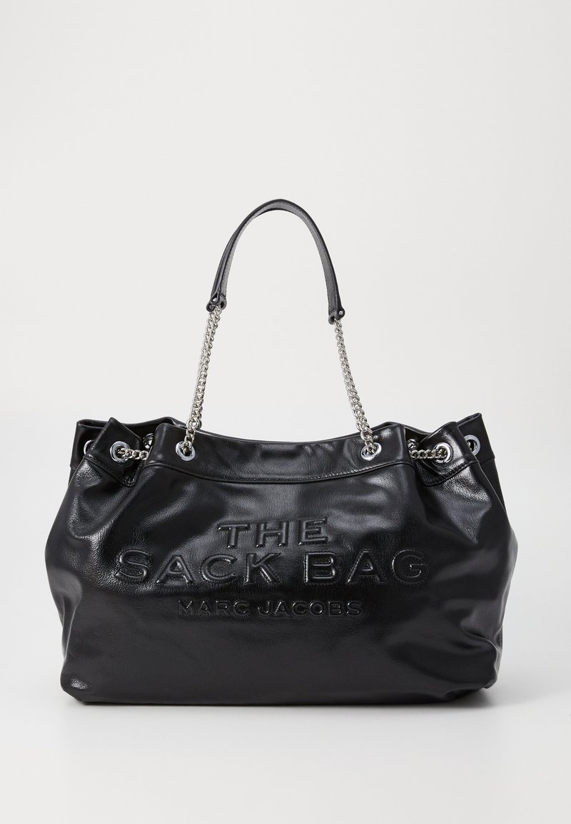 Mustat nahka-tote-laukku, jossa on teksturoitu pinta, hopeiset ketjukahvat ja kohokuvioitu teksti "THE SACK BAG MARG JACOBS."