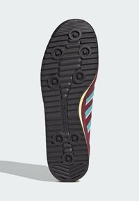 Černá gumová podrážka obuvi s vzorovanými gripy, vínové boční strany a světle modré pruhy. Obsahuje zlatý akcent podél okraje.