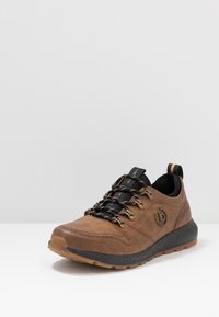 Baskets en cuir marron avec lacets noirs et œillets métalliques. Semelle intermédiaire texturée et détail de marque. Semelle extérieure en caoutchouc pour une meilleure adhérence.