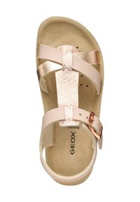 Sandale rose clair avec des sangles entrecroisées, accents métalliques dorés et une semelle texturée. Équipée d'une boucle sur le côté pour un ajustement.