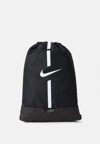 Fekete húzózsinóros hátizsák sima felülettel, feh�ér Nike logóval és függőleges fehér csíkkal az elején.