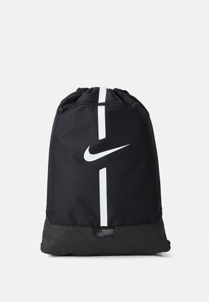 Zaino nero con coulisse, dal tessuto liscio, con il logo Nike bianco e un design a strisce verticali bianche sul davanti.