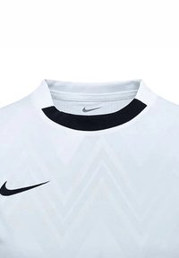 Weißes Sporttrikot mit schwarzem Kragen. Verfügt über ein dezentes Chevron-Muster und ein schwarzes Nike-Logo auf der Brust.
