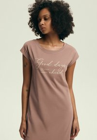 Jasno brązowa sukienka do kolan, wykonana z miękkiego materiału, z okrągłym dekoltem i krótkimi rękawami, z białym nadrukiem tekstu: "Dobre dni..."