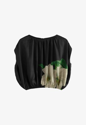 Black blouse with elastic hem, featuring a large white floral print on one side. Made from a smooth, lightweight fabric.