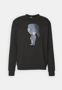 Felpa nera con una stampa fumettistica argento di un personaggio che indossa occhiali da sole e un completo. Presenta un collo a giro e polsini a costine.