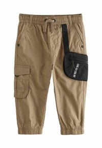 Beige Cargo-Hosen mit elastischem Bund und Kordelzug. Mit Seitentaschen und einem schwarzen Reißverschlussbeutel mit Aufschrift. Elastische Bündchen an den Knöcheln.