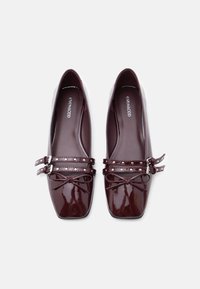 Μοβ σκούρα μπαλαρίνες από δέρμα με λουστρίνι, με τετράγωνη μύτη, διπλούς ιμάντες με αγκράφες και διακοσμητικό φιόγκο, με λεία, γυαλιστερή επιφάνεια.