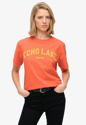 Orange Baumwoll-T-Shirt mit einem gelben "ECHO LAKE"-Grafik und "Superdry"-Text. Mit kurzen Ärmeln und Rundhalsausschnitt.