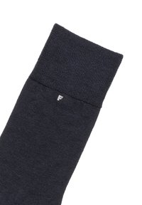 Dunkelblaue Socke mit einem gerippten Bund, aus weichem Stoff gefertigt, mit einem kleinen weißen Logo an der Seite nahe der Oberkante.
