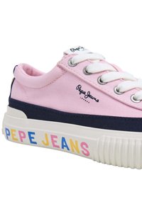 Roza platnena tenisica s mornarsko plavim naglascima, bijelim vezicama i debelim potplatom. Ima "Pepe Jeans" oznaku u šarenim slovima sa strane.