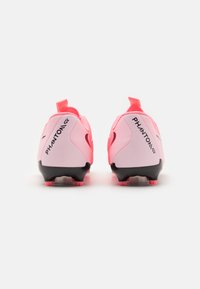 Des crampons de football roses avec une tige en synthétique, une semelle noire, un logo bien visible sur les côtés et un talon texturé pour une meilleure adhérence.