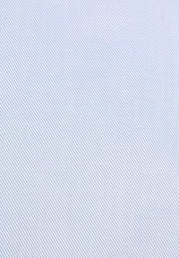 Lichtblauwe stof met een diagonale gestreepte patroon. Zachte textuur met afwisselend dunne witte strepen die een subtiel contrast creëren.