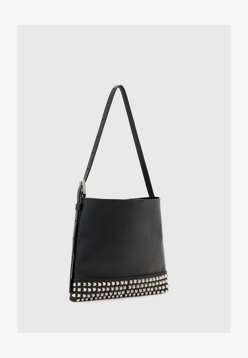 Czarna skórzana torba na ramię o prostokątnym kształcie, z ozdobami w postaci srebrnych stalowych ćwieków na dole i regulowanym paskiem.