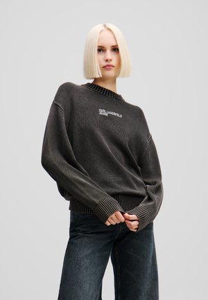 Maglione oversize grigio scuro a maglia, con collo e polsini a coste, caratterizzato da un logo bianco "KARL LAGERFELD JEANS" sulla parte anteriore.