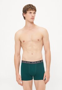 Grüne Baumwoll-Boxershorts mit einem schwarzen Bund, der mit "PIER ONE" beschriftet ist. Sie verfügen über ein tailliertes Design und nahtlose Verarbeitung.