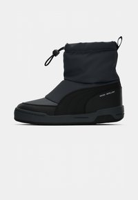 Waterafstotende zwarte boot met een hoge, gepolsterde enkel, een gestructureerde rubberen zool en een verstelbare sluiting voor een perfecte pasvorm. Glad en duurzaam materiaal.