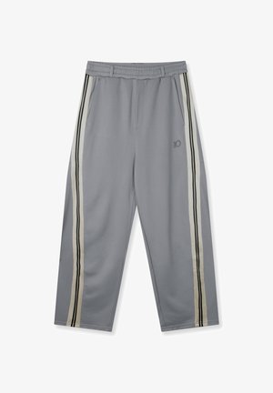 Pantalones deportivos grises con cinturilla elástica, que cuentan con dos bolsillos laterales y rayas verticales en negro y blanco roto en cada lado.