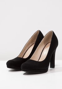 Černé semišové vysoké podpatky s kulatou špičkou, výška podpatku přibližně 10 cm a platforma, s hladkým vnitřním podšímáním.