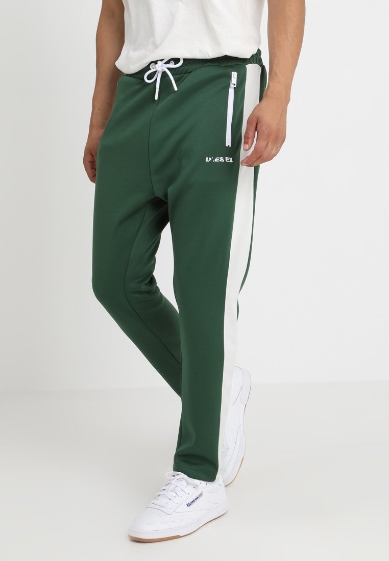 Gröna joggers med vita sidostråk, tillverkade av slätt tyg, med dragsko i midjan och en dragkedjeficka på framsidan.