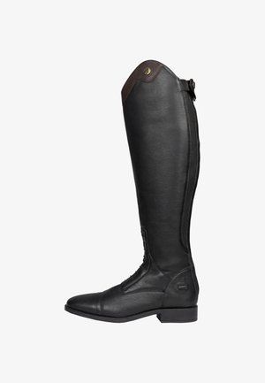 Bota alta de montar de cuero negro con cordones delanteros, ribete superior de cuero marrón y correa con hebilla en el talón trasero y borde superior.