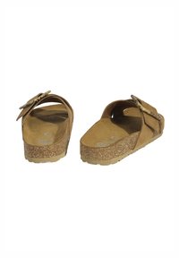 Sandales en suède marron avec deux sangles réglables, semelle en liège et semelle intérieure texturée. Conception à dos ouvert pour un enfilage facile et un confort optimal.